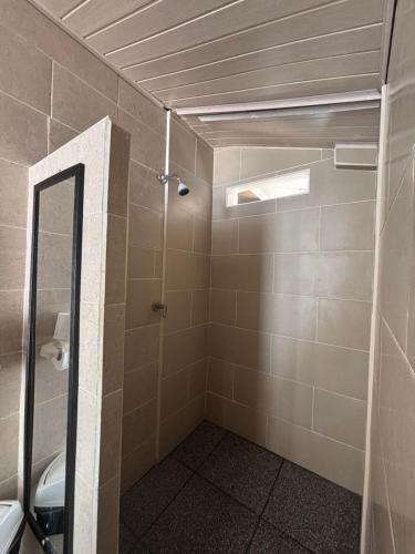 a bathroom with a shower and a mirror at Conchal Maquito House in Brasilito