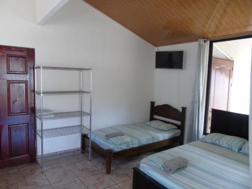 a bedroom with two twin beds and a tv at Conchal Maquito House in Brasilito