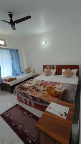a hotel room with two beds and a table and a bed at Trance Himalaya in Gupta Kāshi