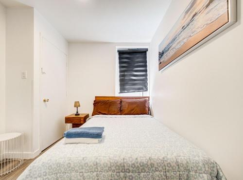 ein kleines Schlafzimmer mit einem Bett und einem Fenster in der Unterkunft Griffintown Hideout in Montreal