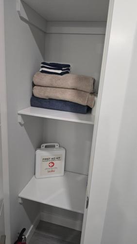 ein weißer Schrank mit Handtüchern und einer Waage darin in der Unterkunft Koko Suites in Regina