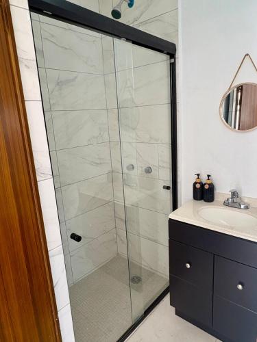 a glass shower in a bathroom with a sink at Casa Flamingo, San Carlos in San Carlos