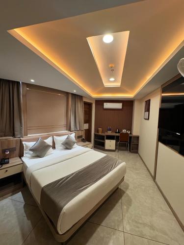 a hotel room with a large bed and a desk at Mezkar Residency in Alwaye
