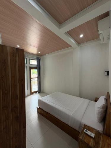 a bedroom with a large bed and a large window at La Casa de Maria in Komodo Labuan Bajo Airport