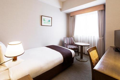 Tempat tidur dalam kamar di HOTEL MYSTAYS Sapporo Aspen
