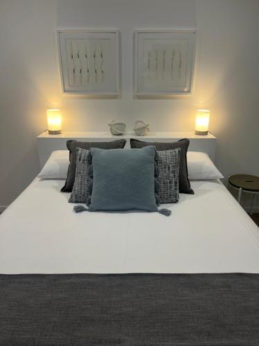 a white bed with two lights on top of it at Somerset Palms Studio Apartment in Horseshoe Bay