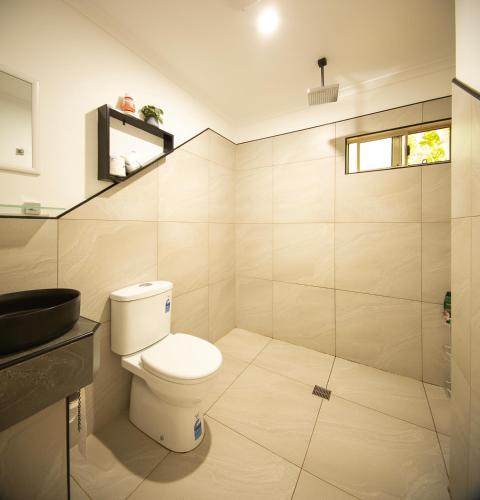 a bathroom with a toilet and a glass shower at Vista Hinchinbrook in Cardwell