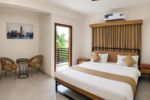 ein Schlafzimmer mit einem großen Bett, einem Tisch und Stühlen in der Unterkunft DeVerveil Service Apartment in Mysore