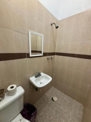 a bathroom with a sink and a toilet and a mirror at Hotel Luxi in Playa Azul
