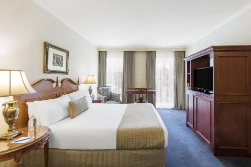 a hotel room with a bed and a television at Canterbury International Hotel in Forest Hill