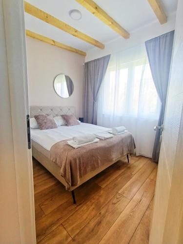 a bedroom with a large bed with blue curtains at Kucica na Drini MINJA in Višegrad