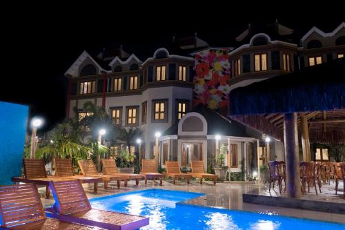 un complejo con piscina frente a un edificio en Pousada Castello Montemare, en Ubatuba