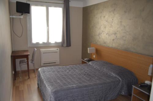 a hotel room with a bed and a window at Hotel Regina in Sète