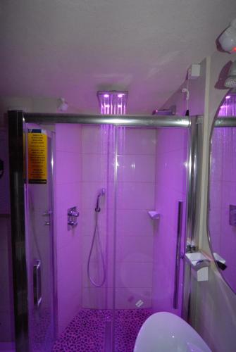 a purple bathroom with a shower with a toilet at Piolet Panoramic Apartments in Breuil-Cervinia