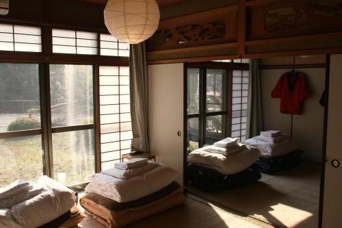 a room with three beds in a room with windows at 88 House Hiroshima in Hiroshima
