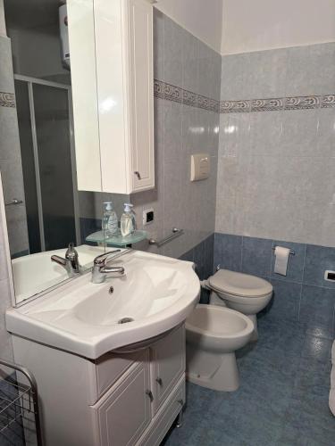 a bathroom with a white sink and a toilet at Casa tranquilla e indipendente in Reggio di Calabria