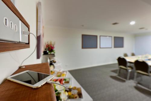 a room with a table with a cell phone on a counter at Tall Trees Ainslie Motel in Canberra