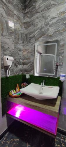 a bathroom with a sink and a mirror with purple lights at Ella T&D Resort in Ella