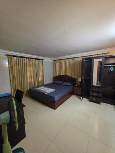 a bedroom with a bed and a dresser and a television at Toul Sleng Double Room in Phnom Penh