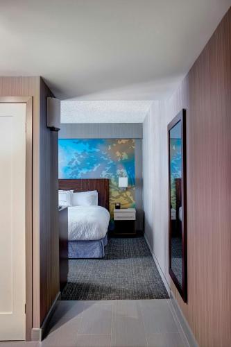 a hotel room with a bed and a mirror at Courtyard by Marriott Toronto Downtown in Toronto