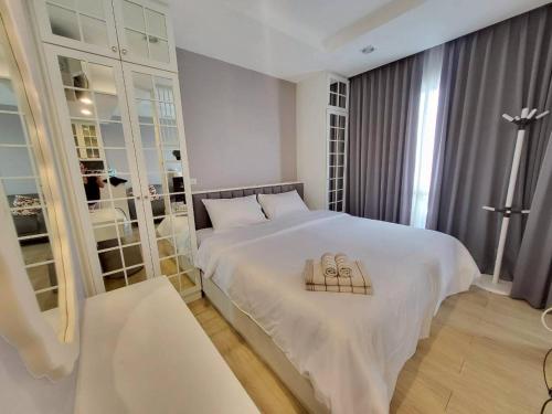 a bedroom with a large white bed with a pillow on it at The Patio See Sea 155 in Ban Bang Saen (1)