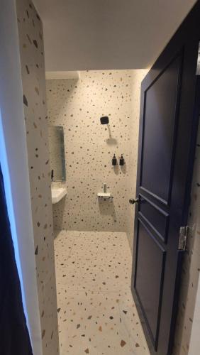 a bathroom with a shower and a sink and a door at BLEU by NIRVANA in Mahabalipuram