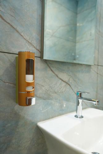 a soap dispenser on a wall next to a sink at HOTEL AIKAA in Hyderabad