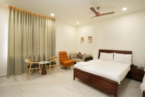 a bedroom with a bed and a chair and a couch at HOTEL AIKAA in Hyderabad