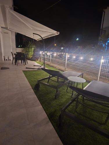 a patio with tables and a white canopy at night at Home23Jesolo! Beach, Parking and Bikes included in Lido di Jesolo