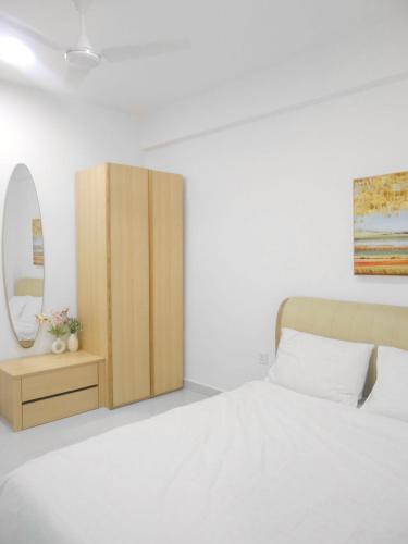 a bedroom with a bed and a dresser with a mirror at Bougainvillea Breeze in Male City