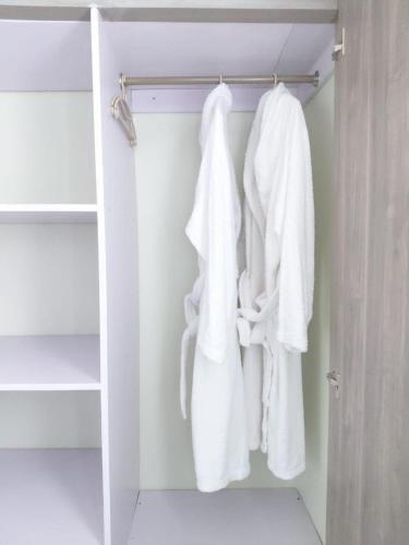a closet with white towels hanging on a rack at Keirwa in Kampala