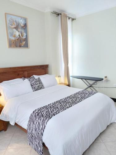 a bedroom with a bed with a zebra print blanket at Keirwa in Kampala