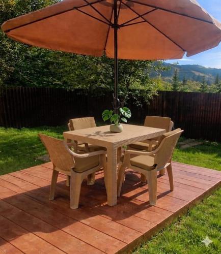 a table and chairs with an umbrella on a patio at Casa Vatra Dornei in Vatra Dornei
