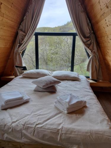 ein Bett in einem Zimmer mit einem großen Fenster in der Unterkunft Mura Doftana in Seciuri