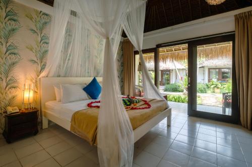 a bedroom with a bed with a canopy at Bali Mystique Hotel & Apartment Seminyak in Seminyak