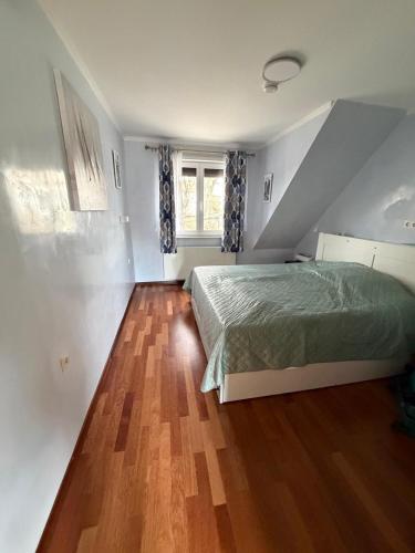 a bedroom with a bed and a wooden floor at Apartments Nicole in Baden