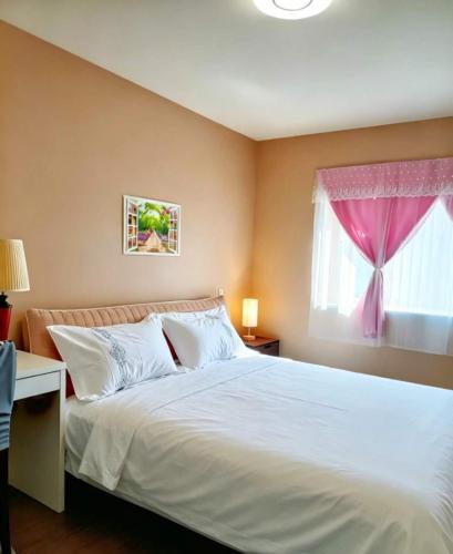 a bedroom with a white bed with a pink window at Cozy Home in Vancouver in Vancouver