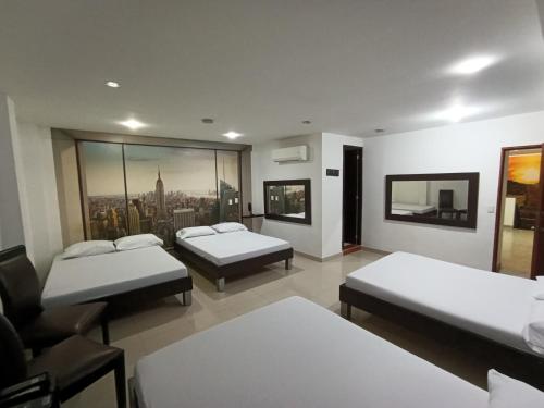 a room with two beds and a couch and a room with at Hotel Cielo de Tambores in Cali