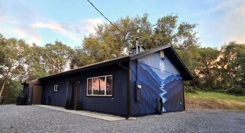 a blue shed with a window in a parking lot at The fancy Shanty in Pilot Hill