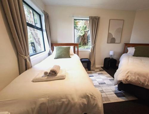 a bedroom with two beds with towels on them at 2-bedroom harbour view apartment with parking, 8 mins to Dunedin in Dunedin