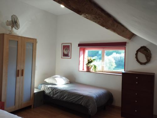 a bedroom with two beds and a window at La Maison Bleue23 in Sardent