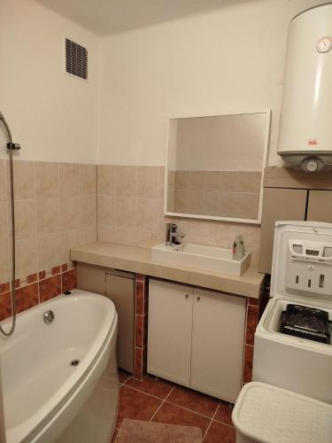 a bathroom with a tub and a sink and a toilet at Harmónia 2 in Mýto pod Ďumbierom