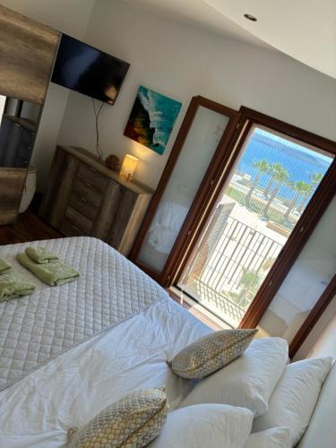 a bedroom with a bed and a large window at Fort Chambray Island Views in Għajnsielem