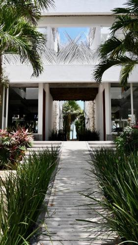 a white house with a walkway in front of it at TULUM Beachfront Villa Kiin in Tulum