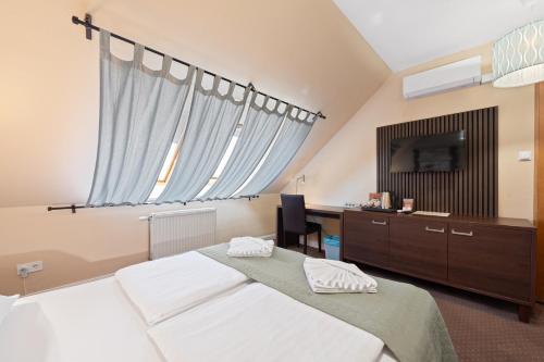 a bedroom with a large bed and a television at Boulevard City Panzió - self check-in in Budapest