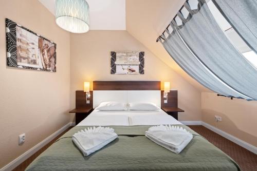 a bedroom with a large bed with a large window at Boulevard City Panzió - self check-in in Budapest