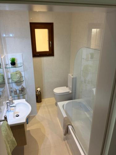 a bathroom with a toilet and a sink and a shower at Fort Chambray Island Views in Għajnsielem