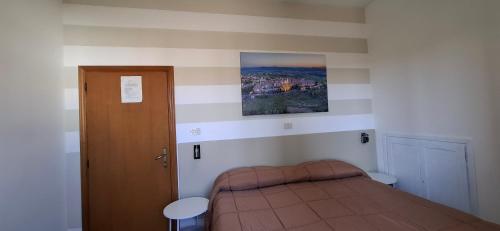 a small bedroom with a bed and a door at Affittacamere Dal Falco in Pienza