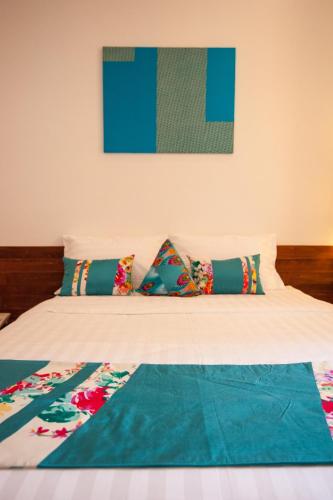a bed with colorful pillows on top of it at House Boutique Eco Hotel in Phnom Penh