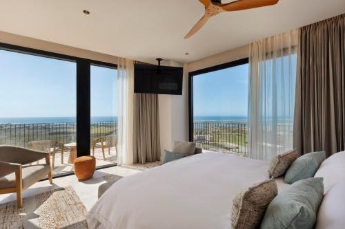 a bedroom with a large bed and large windows at Gordonia Zikhron Ya'akov in Zikhron Ya'akov